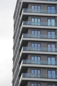 Contemporary architecture featuring stacked glass balconies on a high-rise building facade.